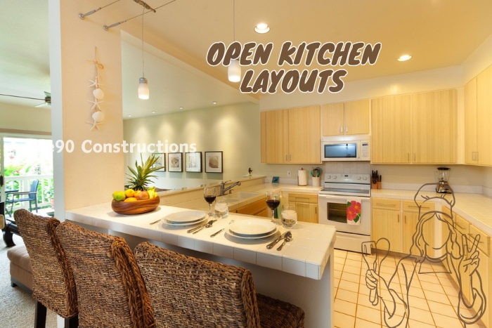 Open kitchen layout in Coimbatore by Angle90 Constructions, featuring a spacious countertop dining area, wicker chairs, and modern cabinetry for a functional and stylish modular kitchen design