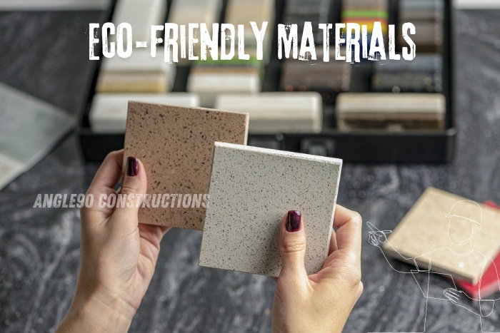 Hands holding eco-friendly building materials with samples in background, showcasing sustainable construction options by Angle90 Constructions in Coimbatore