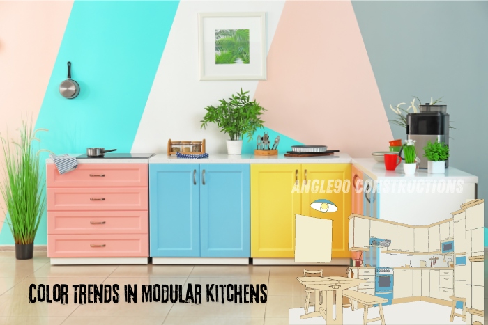 Colorful modular kitchen featuring pink, blue, yellow, and white cabinetry, showcasing modern design trends by Angle90 Constructions in Coimbatore.