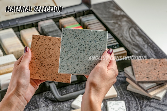 Hands selecting kitchen countertop materials and tiles during the modular kitchen design process by Angle90 Constructions in Coimbatore